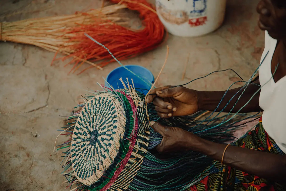 woman weaves frafra basket outdoor