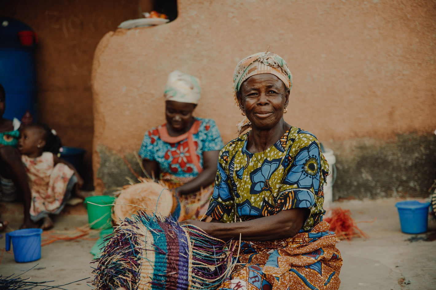  A smiling woman from Ghana, Africa weaves a Frafra basket from Veta Vera Grass