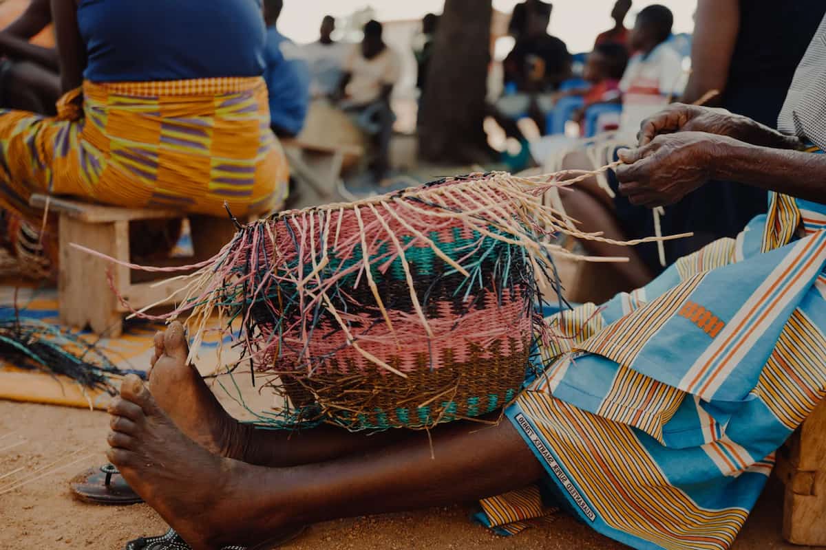 woman from Ghana weaves Frafra baskets on fer legs