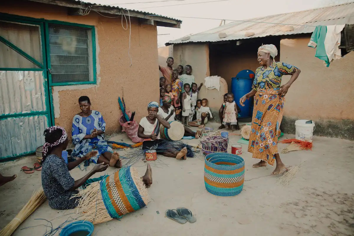 smiling frafra basket weavers standing and sitting outside