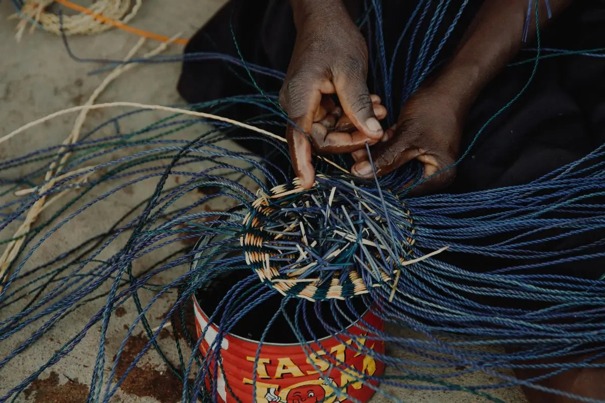 close up of hands weaving eco friendly Frafra baskets