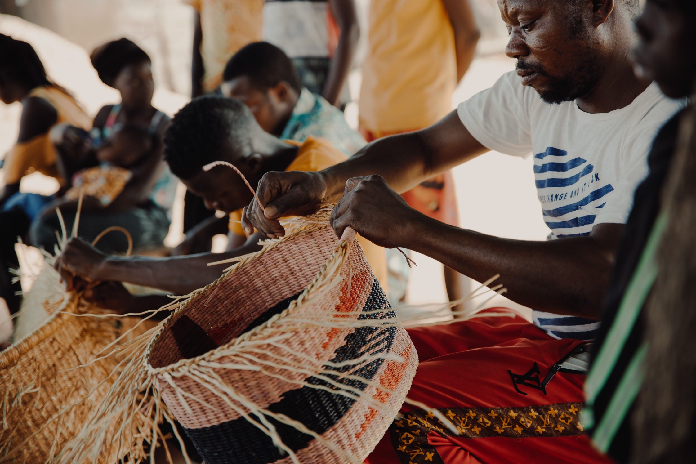  view of people weaving frafra baskets